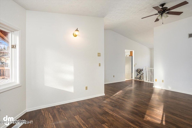 unfurnished room with a textured ceiling, baseboards, vaulted ceiling, and dark wood-style flooring