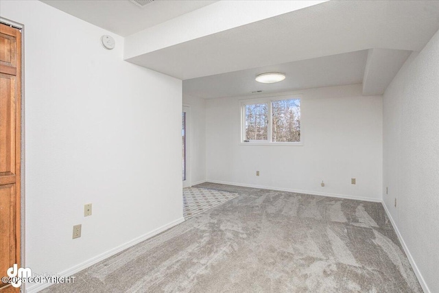 carpeted spare room featuring baseboards