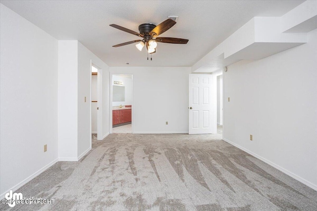 empty room with ceiling fan, baseboards, and light colored carpet