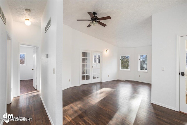 unfurnished room with baseboards, visible vents, dark wood-style floors, a textured ceiling, and french doors