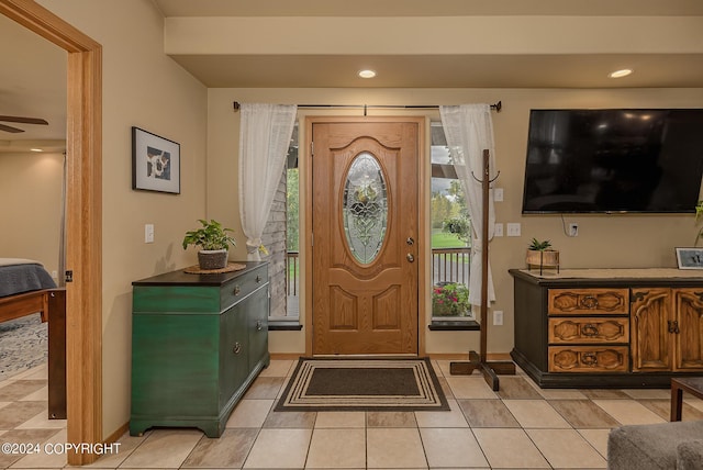 tiled foyer featuring ceiling fan