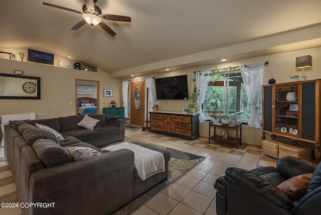 living room with ceiling fan, lofted ceiling, and light tile patterned floors