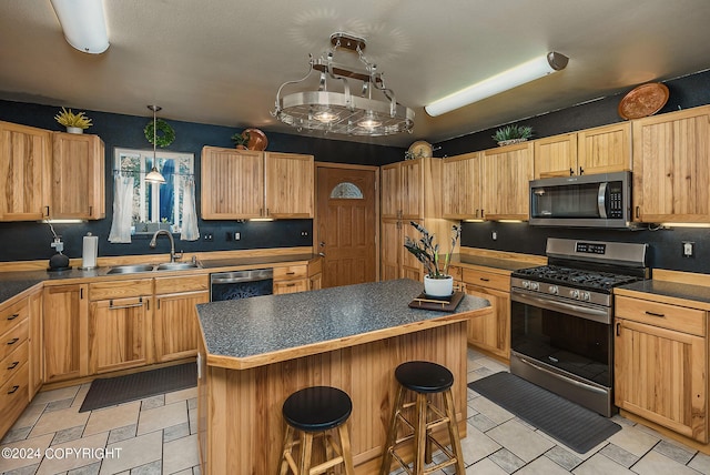 kitchen featuring sink, hanging light fixtures, a kitchen breakfast bar, a kitchen island, and stainless steel appliances