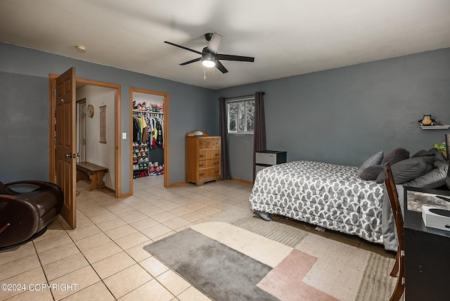 bedroom featuring a spacious closet, a closet, ceiling fan, and light tile patterned flooring