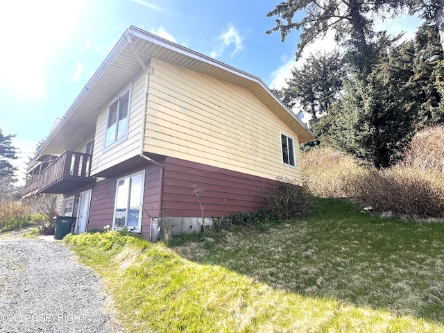 view of property exterior with a lawn and a balcony