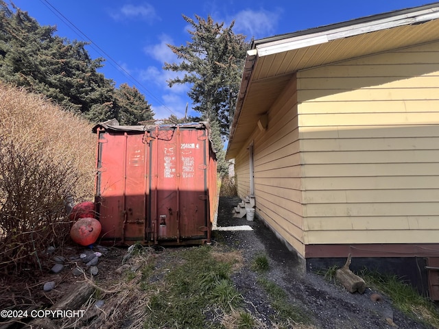 view of side of home featuring a shed