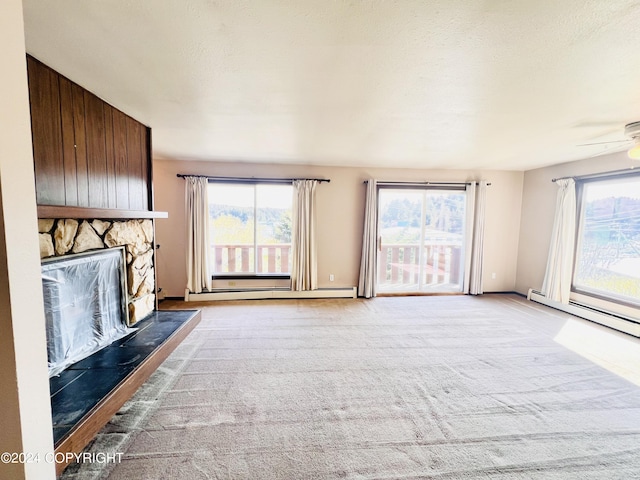 unfurnished living room featuring plenty of natural light, a stone fireplace, and carpet flooring