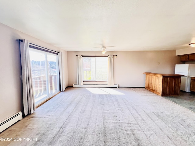 empty room featuring baseboard heating, ceiling fan, and light colored carpet