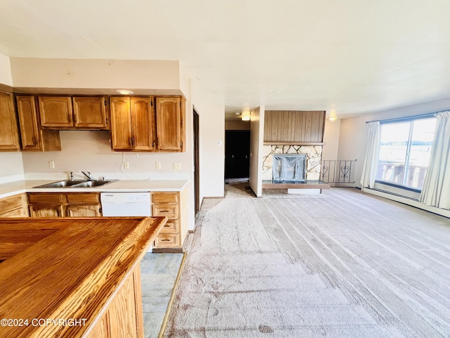 kitchen featuring light carpet, sink, and white dishwasher