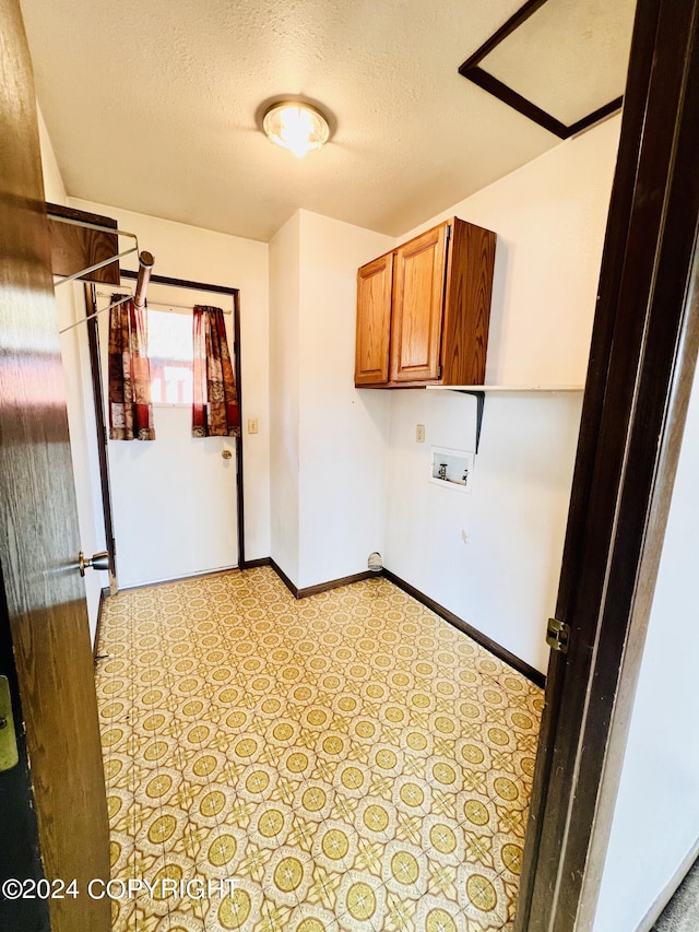 laundry area with cabinets, washer hookup, light tile flooring, and a textured ceiling