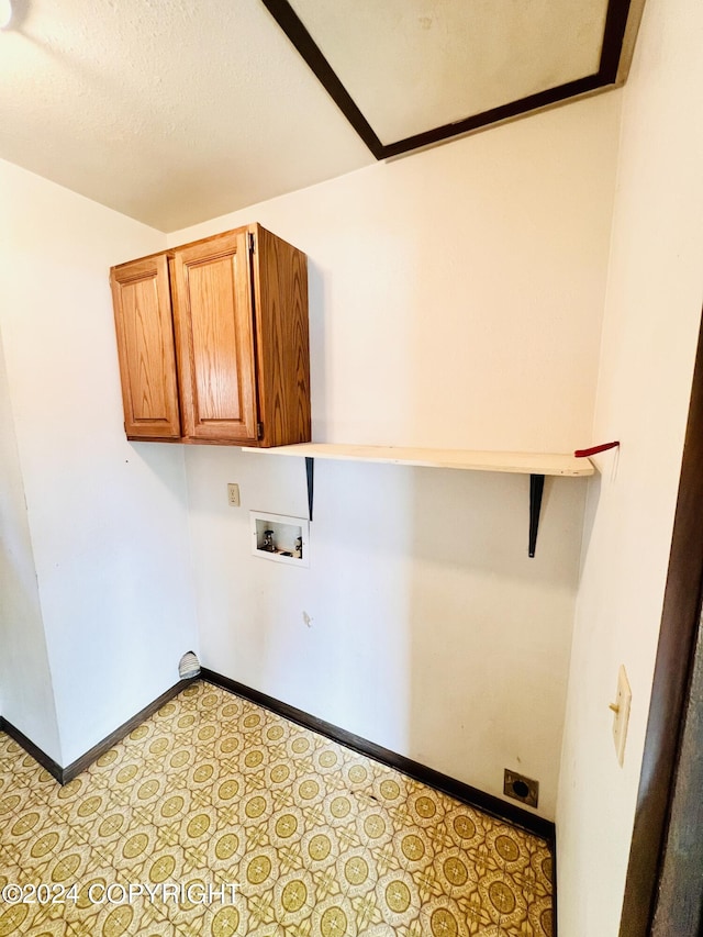 laundry room featuring cabinets, hookup for an electric dryer, light tile flooring, and hookup for a washing machine