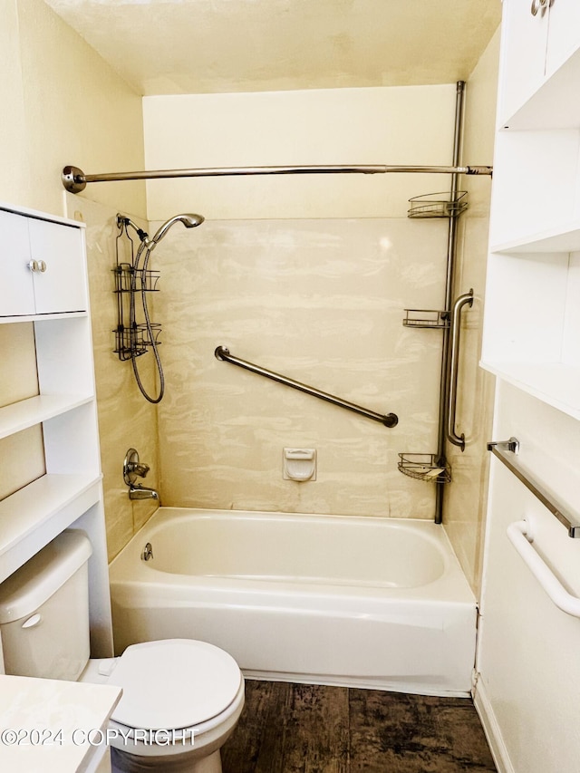 bathroom with tiled shower / bath combo, wood-type flooring, and toilet