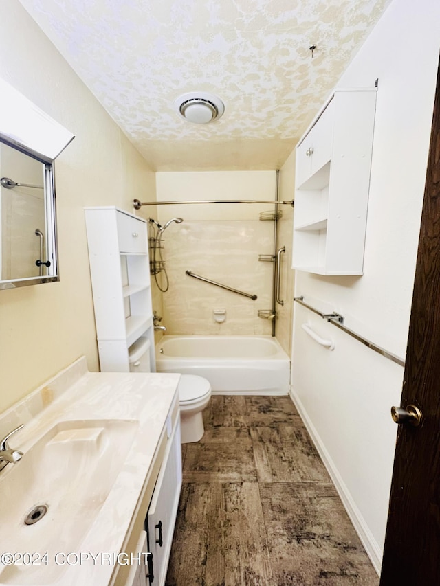 full bathroom featuring a textured ceiling, large vanity, bathing tub / shower combination, and toilet