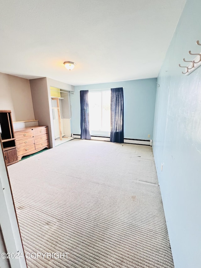 unfurnished bedroom with a baseboard radiator and carpet floors