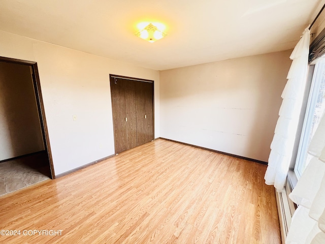 unfurnished bedroom with a closet and light wood-type flooring