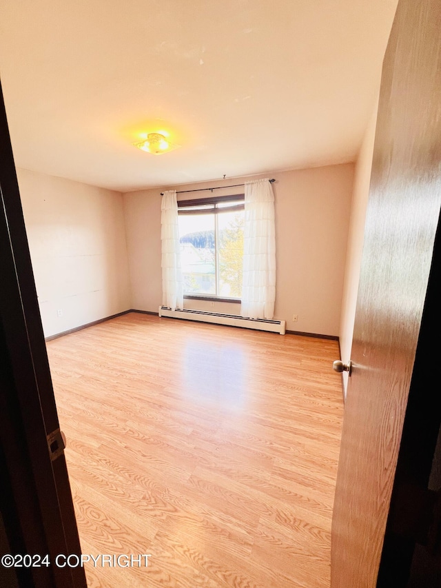 spare room with light hardwood / wood-style floors and baseboard heating