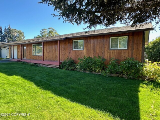 view of side of home with a yard