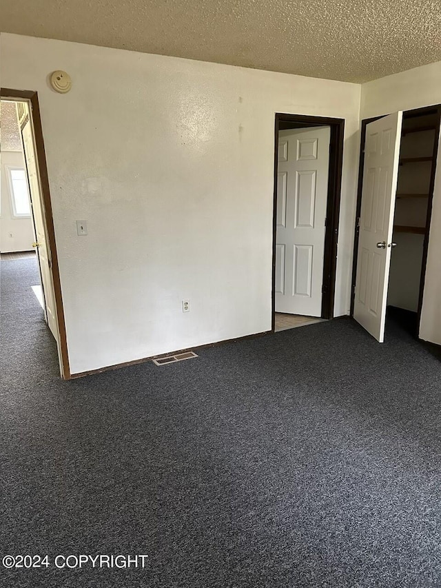 unfurnished bedroom with carpet flooring and a textured ceiling