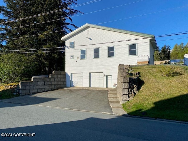 view of home's exterior with a garage and a lawn