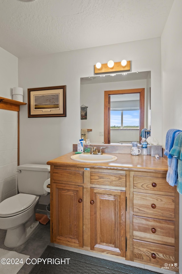 bathroom featuring vanity, toilet, and a textured ceiling