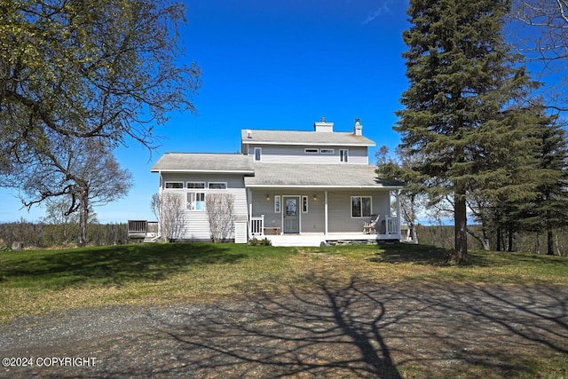 rear view of house featuring a lawn and a porch