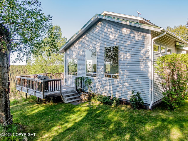 rear view of property with a yard and a wooden deck