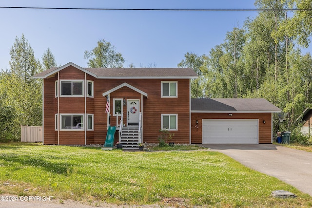 raised ranch with a front lawn and a garage