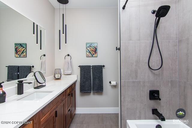 bathroom featuring tile flooring, tiled shower / bath combo, and vanity with extensive cabinet space