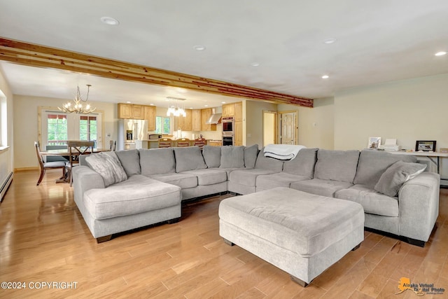 living room with an inviting chandelier, beam ceiling, and light wood-type flooring