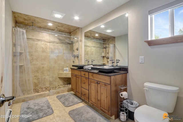 bathroom featuring vanity, tiled shower, tile patterned floors, and toilet