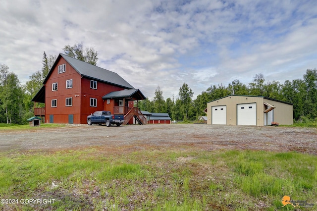 view of side of property with an outbuilding, a garage, and a deck