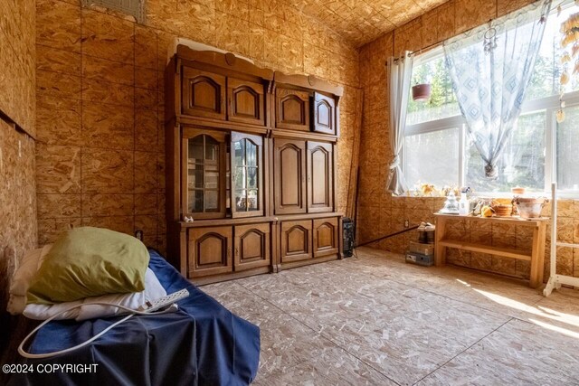 sitting room featuring brick ceiling and lofted ceiling