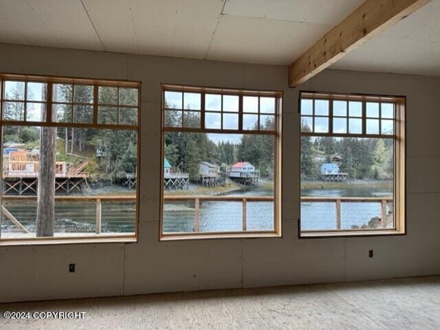 interior space featuring beamed ceiling and a water view