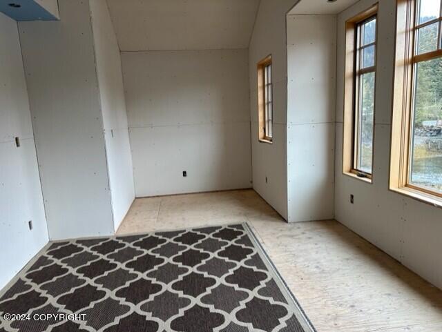 unfurnished room featuring vaulted ceiling