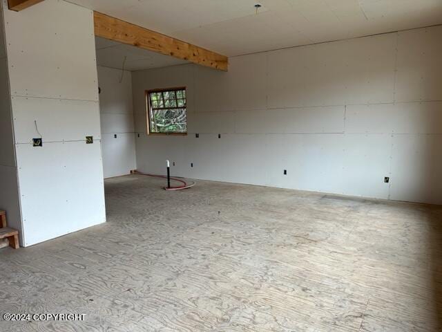 unfurnished room featuring beam ceiling