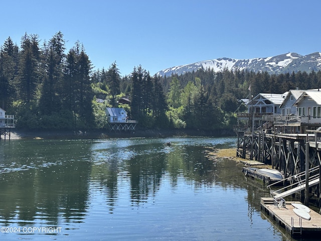 property view of water featuring a dock and a mountain view