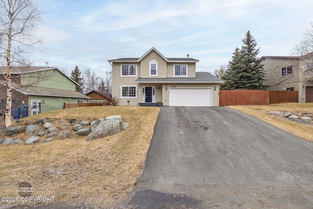 view of front of house featuring driveway, a garage, and fence