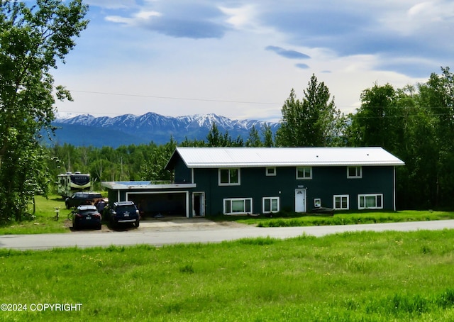 view of front of house featuring a mountain view and a front lawn