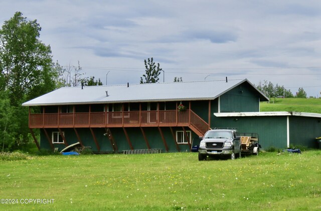 rear view of property with a deck and a yard