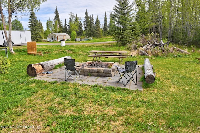 view of yard featuring an outdoor fire pit and a patio