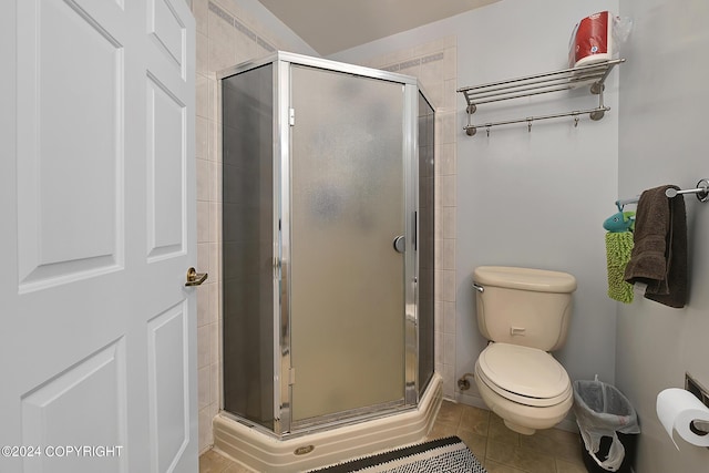 bathroom featuring walk in shower, toilet, and tile patterned flooring