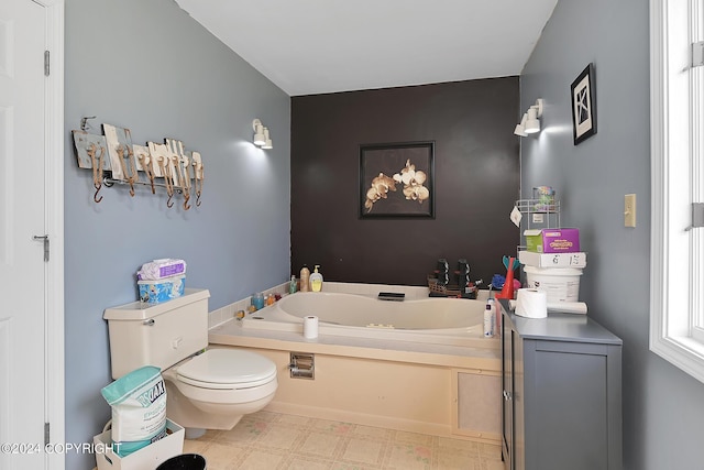 bathroom with a tub to relax in and toilet