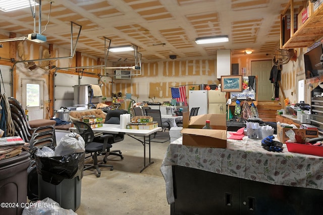 garage with a garage door opener and white fridge