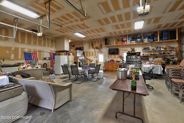 garage with white refrigerator and a garage door opener