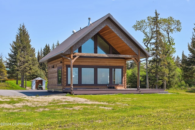 rear view of property featuring a yard and a shed