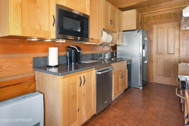 kitchen featuring appliances with stainless steel finishes, sink, light brown cabinets, wooden ceiling, and wood walls