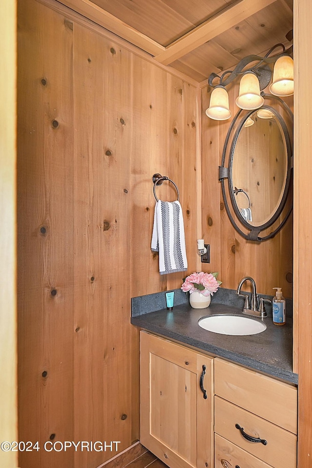 bathroom featuring vanity, wood ceiling, and wooden walls