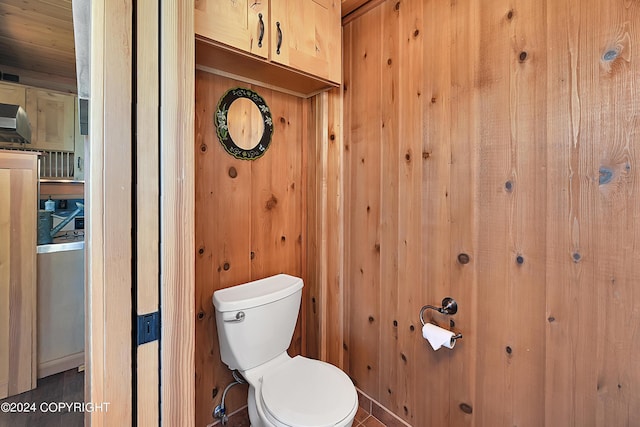 bathroom with wooden walls and toilet