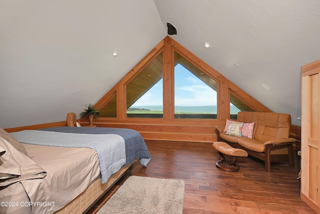 bedroom with hardwood / wood-style flooring, wood walls, and vaulted ceiling