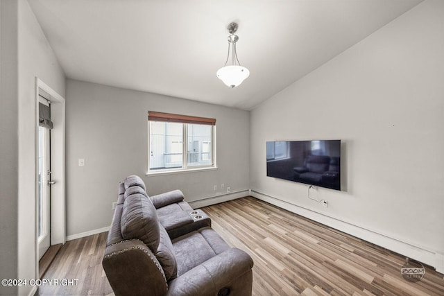 living room with light wood-type flooring, vaulted ceiling, and baseboard heating